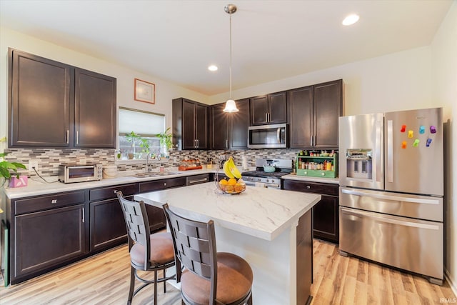 4671 W Hidden Meadow Dr, Bloomington, IN 47404 - kitchen featuring stainless steel appliances, a sink, dark brown cabinets, light wood-style floors, and recessed lighting