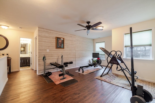 4671 W Hidden Meadow Dr, Bloomington, IN 47404 - workout room featuring an accent wall, wood finished floors, ceiling fan, baseboards, and wooden walls