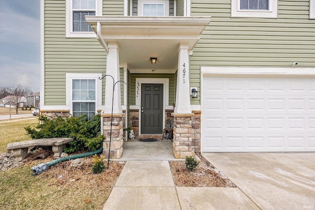 4671 W Hidden Meadow Dr, Bloomington, IN 47404 - doorway to property featuring a garage, stone siding, and concrete driveway