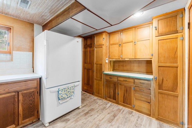 9465 E 1000 N, Syracuse, IN 46567 - kitchen featuring freestanding refrigerator, light wood-style flooring, light countertops, and brown cabinetry