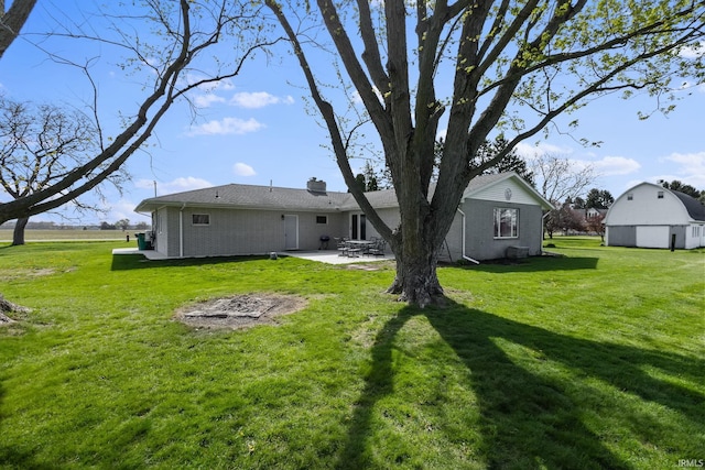 56915 Tulip Rd, New Carlisle, IN 46552 - back of house with a patio area, a yard, brick siding, and a chimney