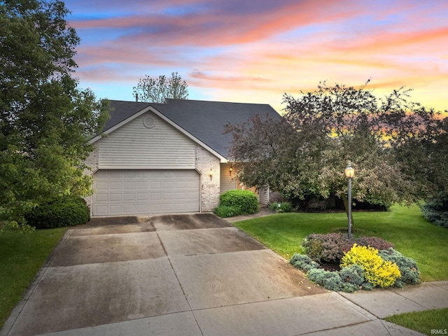 3260 E Sherman St, Columbia City, IN 46725 - view of front of house with concrete driveway, a yard, brick siding, and a garage