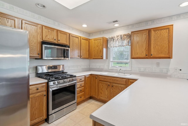 3260 E Sherman St, Columbia City, IN 46725 - kitchen featuring appliances with stainless steel finishes, a sink, light countertops, recessed lighting, and brown cabinets