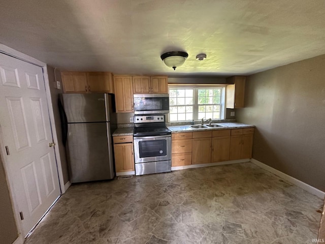 2118 Homewood Ave, Mishawaka, IN 46544 - kitchen with appliances with stainless steel finishes, a sink, baseboards, light countertops, and light brown cabinets