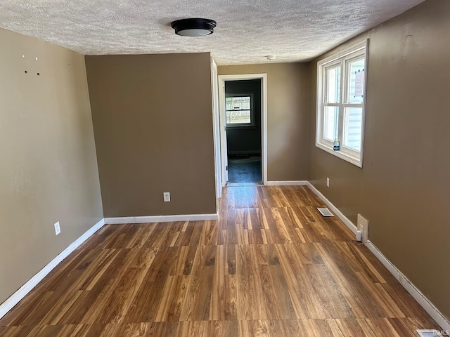 2118 Homewood Ave, Mishawaka, IN 46544 - empty room featuring a textured ceiling, dark wood-style floors, and baseboards