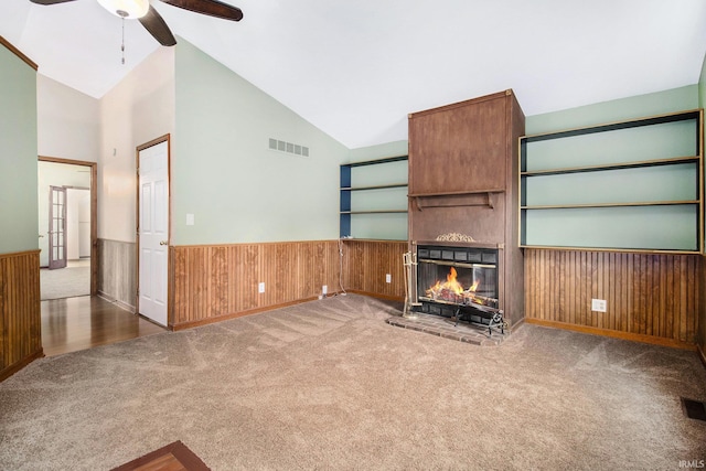724 E Mishawaka Ave, Mishawaka, IN 46545 - unfurnished living room with ceiling fan, carpet, wainscoting, a large fireplace, and wooden walls