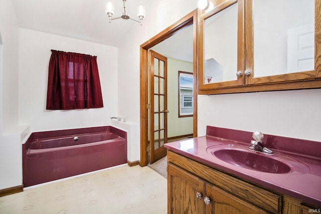 724 E Mishawaka Ave, Mishawaka, IN 46545 - bathroom with a chandelier, vanity, tile patterned floors, and a garden tub