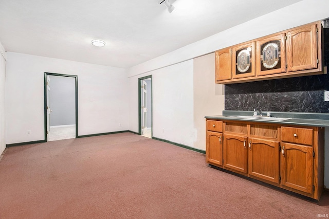 724 E Mishawaka Ave, Mishawaka, IN 46545 - kitchen with light colored carpet, decorative backsplash, brown cabinets, and baseboards