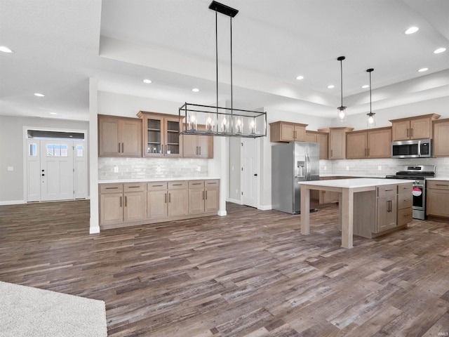 16927 Hillsong Ln, Huntertown, IN 46748 - kitchen with appliances with stainless steel finishes, dark wood-type flooring, a tray ceiling, backsplash, and recessed lighting