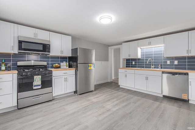 420 W 10th St, Mishawaka, IN 46544 - kitchen with stainless steel appliances, a sink, wooden counters, and white cabinets