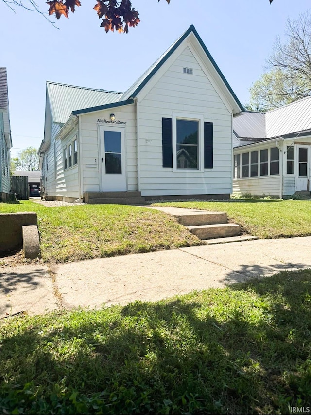 511 E 3rd St, Peru, IN 46970 - back of property featuring metal roof and a lawn