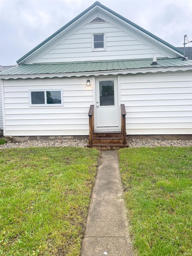 511 E 3rd St, Peru, IN 46970 - view of front facade featuring entry steps, a front lawn, and metal roof