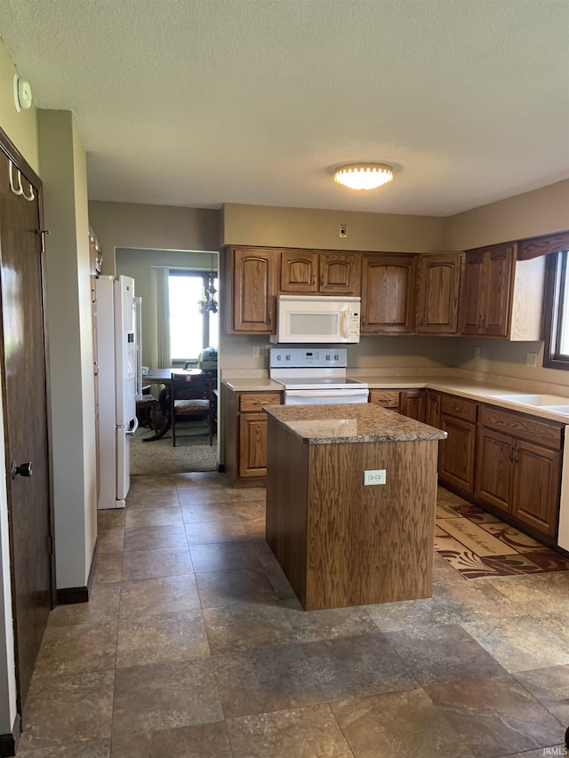 6921 Franke Rd, Fort Wayne, IN 46816 - kitchen with white appliances, a center island, plenty of natural light, a sink, and a textured ceiling