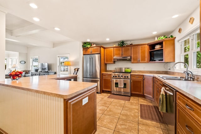 6592 E Waco Dr, Syracuse, IN 46567 - kitchen with stainless steel appliances, a sink, under cabinet range hood, light countertops, and beamed ceiling