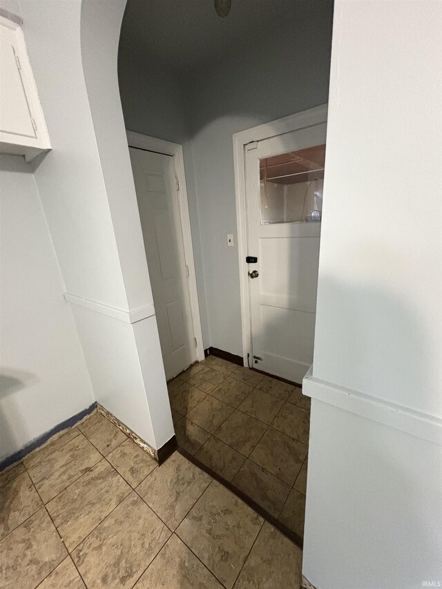 1713 E Illinois St, Evansville, IN 47711 - laundry area with arched walkways, tile patterned floors, and baseboards