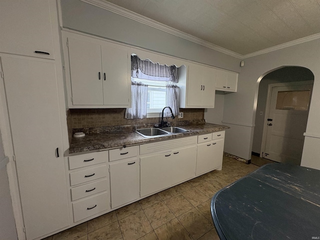 1713 E Illinois St, Evansville, IN 47711 - kitchen featuring a sink, dark countertops, backsplash, white cabinets, and crown molding