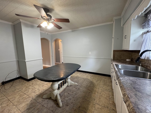 1713 E Illinois St, Evansville, IN 47711 - kitchen featuring a sink, white cabinetry, a ceiling fan, arched walkways, and dark countertops