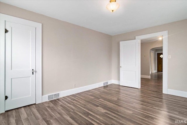 1713 E Illinois St, Evansville, IN 47711 - spare room featuring arched walkways, wood finished floors, and baseboards
