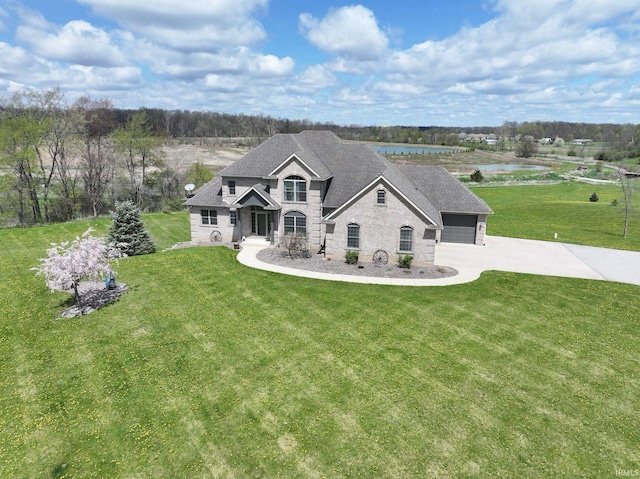 4799 E 500 S Unit 57, Churubusco, IN 46723 - view of front of property with concrete driveway, a front yard, a water view, roof with shingles, and stone siding