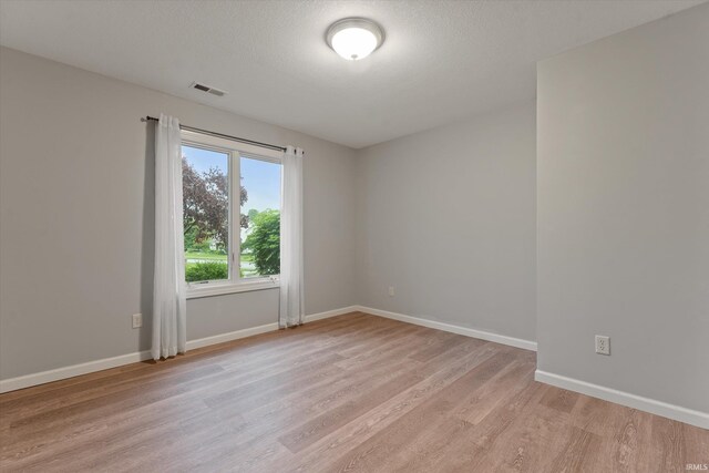32840 Morning Dove Ct, New Carlisle, IN 46552 - unfurnished room with light wood-style floors, baseboards, and a textured ceiling