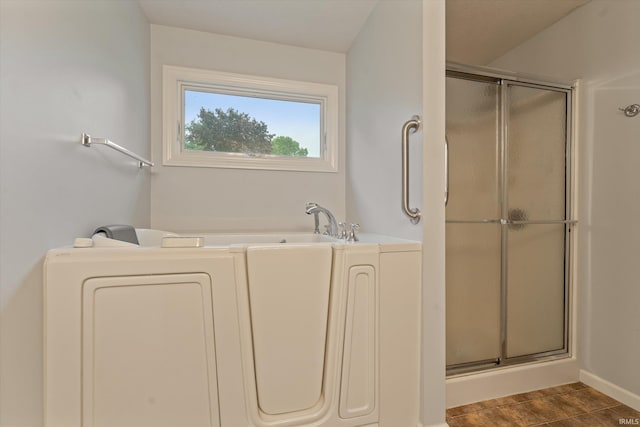 32840 Morning Dove Ct, New Carlisle, IN 46552 - full bath with washer / dryer, a shower stall, a bath, and baseboards