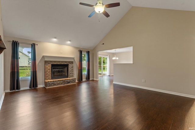 32840 Morning Dove Ct, New Carlisle, IN 46552 - unfurnished living room with a brick fireplace, a ceiling fan, high vaulted ceiling, dark wood-type flooring, and a chandelier