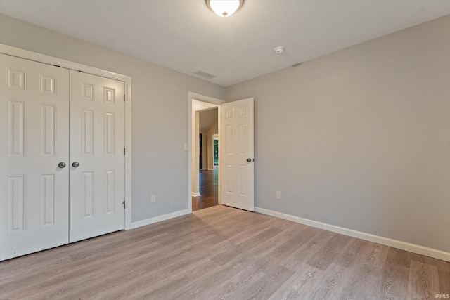 32840 Morning Dove Ct, New Carlisle, IN 46552 - unfurnished bedroom with light wood-style floors, baseboards, and a closet