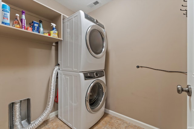 32840 Morning Dove Ct, New Carlisle, IN 46552 - laundry room with stacked washer / drying machine, baseboards, and light tile patterned floors