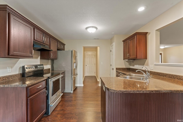 32840 Morning Dove Ct, New Carlisle, IN 46552 - kitchen with stainless steel appliances, a sink, under cabinet range hood, dark countertops, and dark wood-type flooring