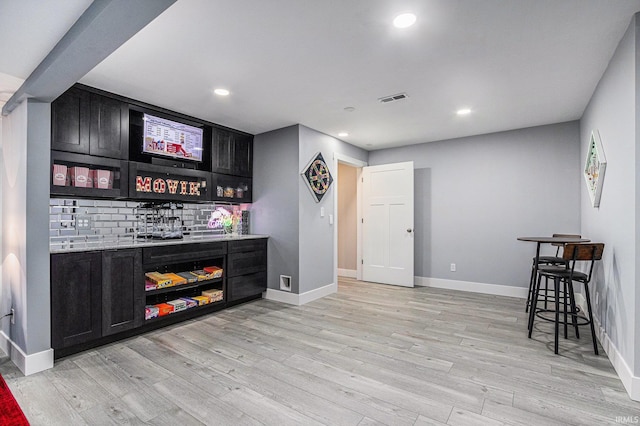 53760 Terre Verde Hills Ct, South Bend, IN 46628 - indoor dry bar with decorative backsplash, light wood-style floors, recessed lighting, and baseboards