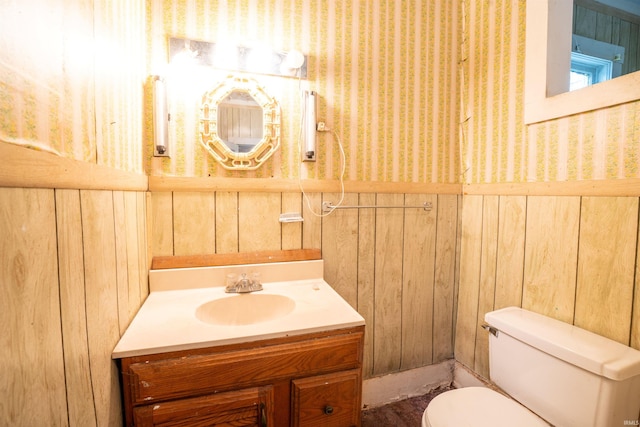 104 S Cowen St, Garrett, IN 46738 - bathroom with toilet, vanity, wooden walls, and wallpapered walls