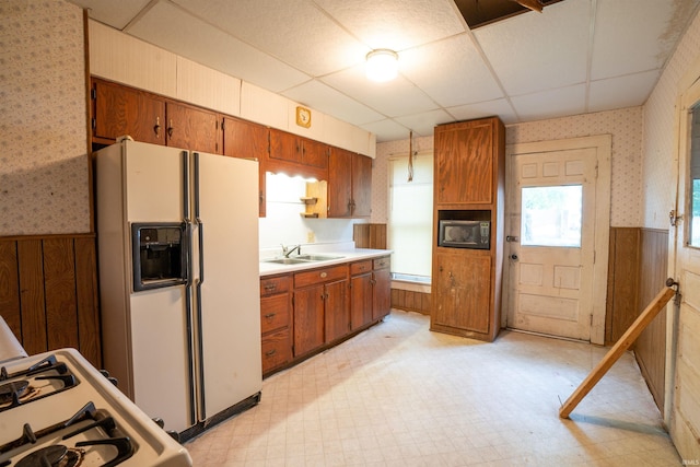 104 S Cowen St, Garrett, IN 46738 - kitchen with white appliances, wallpapered walls, a sink, a wainscoted wall, and light floors