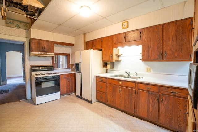 104 S Cowen St, Garrett, IN 46738 - kitchen with gas stove, a sink, white fridge with ice dispenser, under cabinet range hood, and wallpapered walls