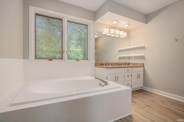 51695 Fox Pointe Ln, Granger, IN 46530 - bathroom with double vanity, a bath, wood finished floors, and baseboards