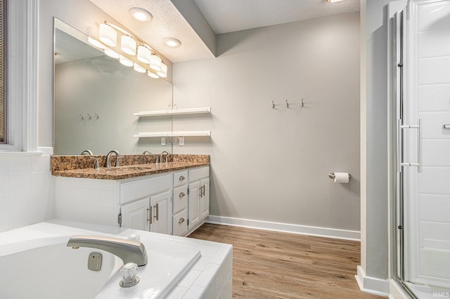 51695 Fox Pointe Ln, Granger, IN 46530 - bathroom featuring double vanity, a bath, wood finished floors, and baseboards