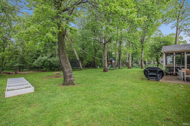 51695 Fox Pointe Ln, Granger, IN 46530 - view of green lawn featuring a playground, a patio area, and a sunroom