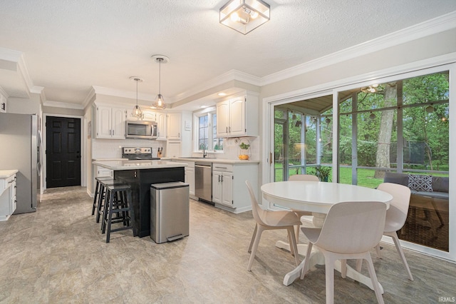 51695 Fox Pointe Ln, Granger, IN 46530 - kitchen with stainless steel appliances, a sink, a center island, light countertops, and a textured ceiling