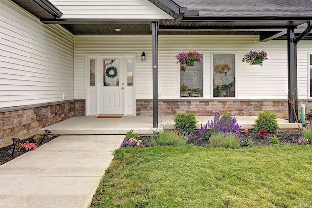 4022 Eagle Dr, Gosport, IN 47433 - doorway to property featuring covered porch, a yard, a shingled roof, and stone siding