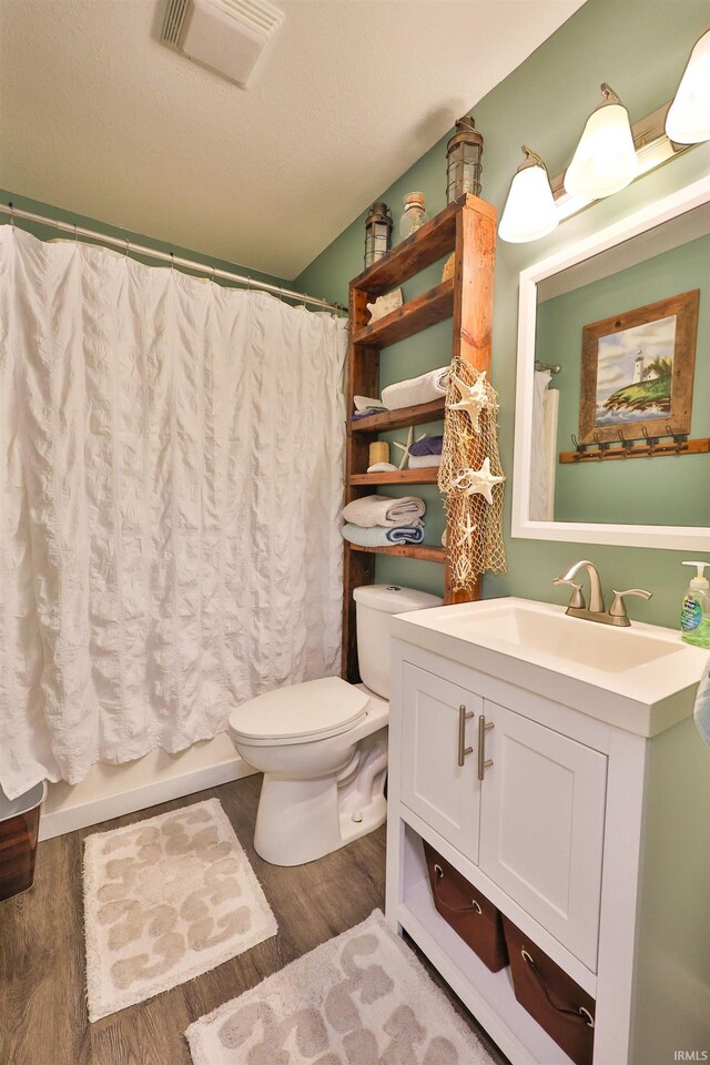 110 Alan Dr, Fremont, IN 46737 - bathroom with toilet, vanity, wood finished floors, and shower / bath combo with shower curtain