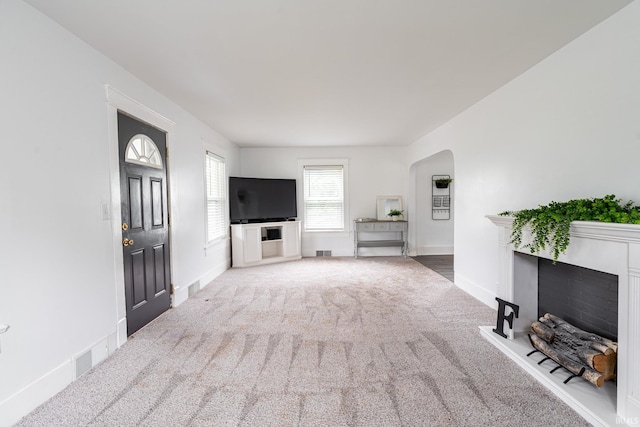 1471 Vernon St, Wabash, IN 46992 - unfurnished living room with carpet floors, a fireplace, arched walkways, and baseboards