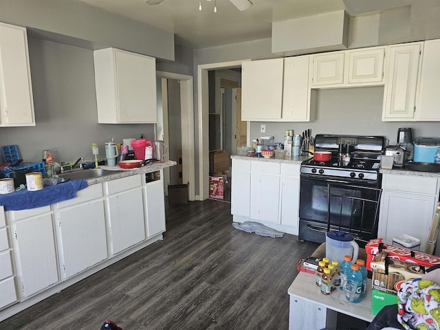 58 E 5th St, Peru, IN 46970 - kitchen with gas stove, a sink, dark wood finished floors, and white cabinetry