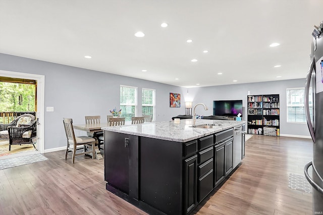 7228 W Mustang Dr, Ellettsville, IN 47429 - kitchen with dark cabinets, a sink, light wood-style flooring, recessed lighting, and a kitchen island with sink
