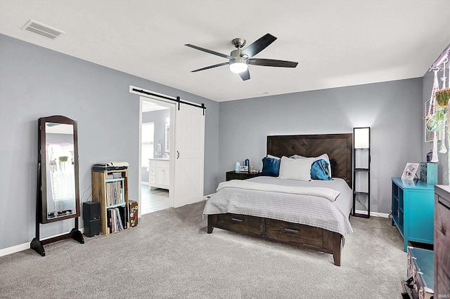 7228 W Mustang Dr, Ellettsville, IN 47429 - carpeted bedroom featuring a barn door, connected bathroom, baseboards, and a ceiling fan