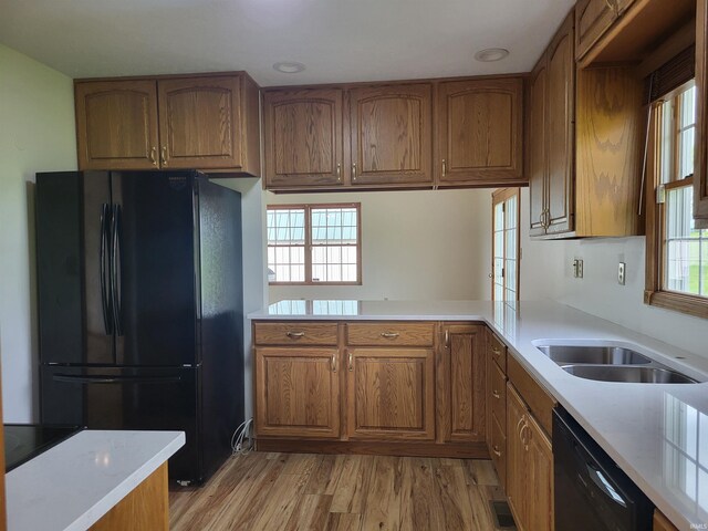104 Leatherwood Creek Ests, Bedford, IN 47421 - kitchen featuring black appliances, brown cabinets, light countertops, light wood-style floors, and a sink