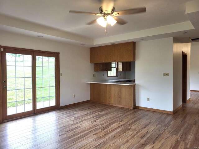 104 Leatherwood Creek Ests, Bedford, IN 47421 - kitchen with a tray ceiling, brown cabinets, baseboards, wood finished floors, and ceiling fan