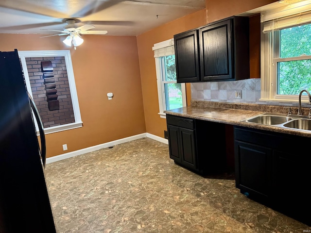 815 3rd St, Huntingburg, IN 47542 - kitchen with freestanding refrigerator, a sink, ceiling fan, decorative backsplash, and dark cabinetry