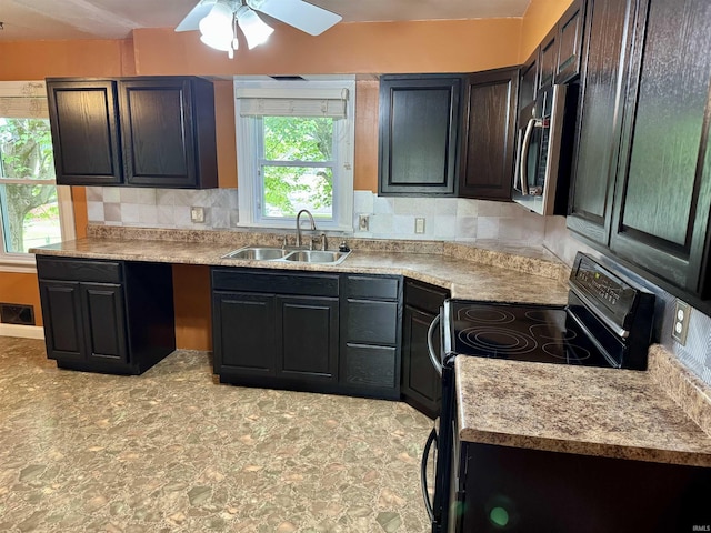 815 3rd St, Huntingburg, IN 47542 - kitchen featuring a sink, stainless steel microwave, black electric range oven, ceiling fan, and backsplash