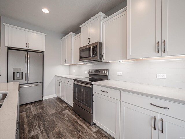 9920 Blyth Dr, Evansville, IN 47725 - kitchen with appliances with stainless steel finishes, dark wood-style floors, white cabinets, tasteful backsplash, and recessed lighting