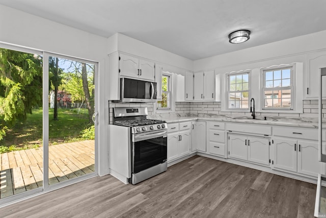 112 W Monroe St, Alexandria, IN 46001 - kitchen featuring appliances with stainless steel finishes, a sink, decorative backsplash, dark wood-type flooring, and white cabinets