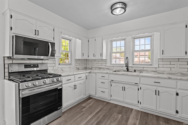 112 W Monroe St, Alexandria, IN 46001 - kitchen with appliances with stainless steel finishes, a sink, white cabinets, and decorative backsplash